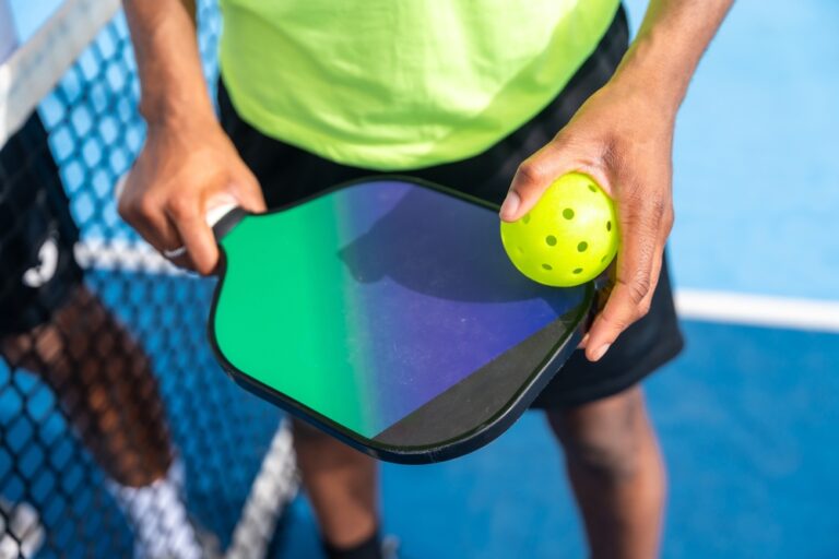 Top,View,Close-up,Of,Man,Holding,Racket,And,Pickleball,Ball